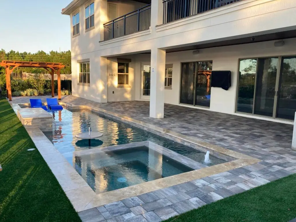 Sealed travertine coping with sealed gray pavers.