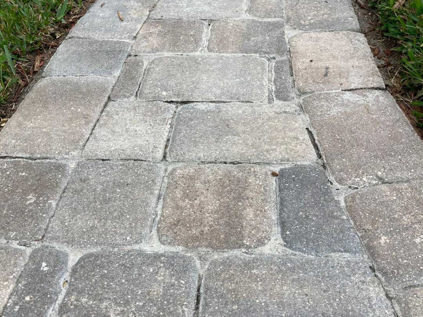 Picture of a walkway with failed sealer. Paver Stripping.